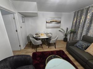a living room with a table and a couch at Hornchurch Cozy 2-Bed Flat with Street Parking in Hornchurch