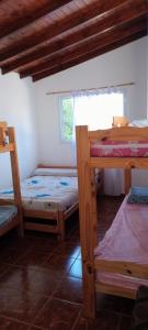 a room with three bunk beds and a window at Luana2 in Villa Gesell