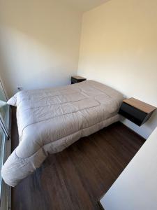 een slaapkamer met een bed met een wit dekbed bij Karü in Aluminé
