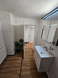 a bathroom with a sink and a mirror at harmonische 2-Zimmer Ferienwohnung in Nörten-Hardenberg