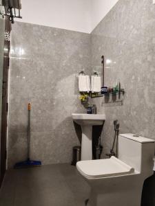 a bathroom with a toilet and a sink at Gruham Homestay in Jorhāt