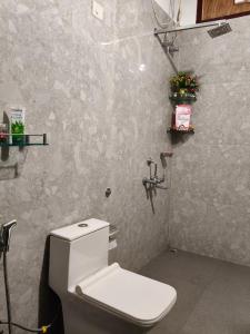a bathroom with a white toilet in a room at Gruham Homestay in Jorhāt +20 photos