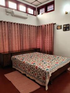 a bedroom with a bed in a room with curtains at Gruham Homestay in Jorhāt