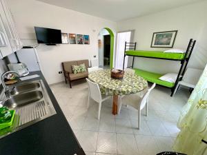 a kitchen with a table and a green bunk bed at ChiarAmare Vacanza, casa con Idromassaggio, vicino Maldive del Salento in Torre Pali