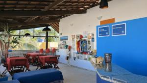 a restaurant with red chairs and a blue counter at FAROL BEACH Suítes in Salvador