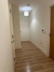 an empty hallway with a door and a wooden floor at Modern-Spacious Dublin Apartment in Dublin