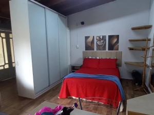 una camera da letto con un letto con una coperta rossa di Kitnet mobiliado da Nice - FUNDOS a Guaíba Altre 17 foto