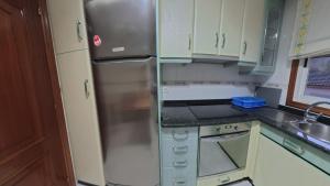 eine Küche mit Edelstahlkühlschrank und Schränken in der Unterkunft Mirador Residencia in Ourense