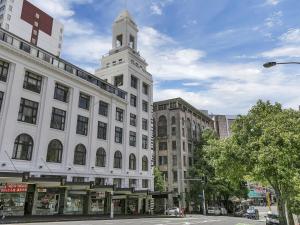 Un edificio blanco con una torre de reloj en la parte superior. en Attic Backpackers, en Auckland
