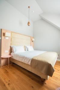 a bedroom with a large bed and a table at The Nest Beneath the Citadel - 5 min to City Square in Râşnov +16 photos