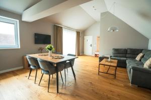 a living room with a table and a couch at The Nest Beneath the Citadel - 5 min to City Square in Râşnov