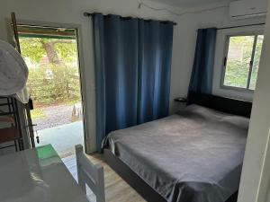 1 dormitorio con 1 cama con cortinas azules y ventana en Tindet, en Playa Hermosa 32 fotos más
