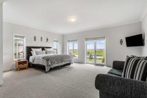 Un pat sau paturi într-o cameră la Sunlit Shores - Papamoa Holiday Homes