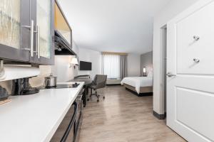 a hotel room with a kitchen and a bed at Candlewood Suites Midland by IHG in Midland