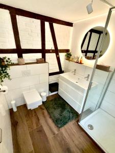 a bathroom with a sink and a glass shower at Historisches Fachwerk Haus am Fluss in Monschau +46 photos