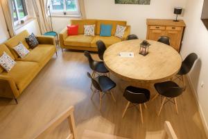 Kaszëbsko Nórcëk 8-10 osób 4 sypialnie jezioro las park linowy łowisko wędkarskie في Załakowo: غرفة معيشة مع طاولة وكراسي وأريكة