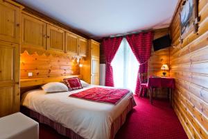 シャテルにあるHôtel Le Tremplinの木製の壁のベッドルーム1室(ベッド1台付)