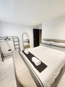 Stunning, Newly Refurbished 1-Bedroom Flat in Gravesend في غريفسيند: سرير ابيض كبير عليه منشفتين