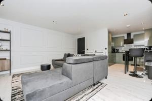 Stunning, Newly Refurbished 1-Bedroom Flat in Gravesend في غريفسيند: غرفة معيشة مع أريكة ومطبخ