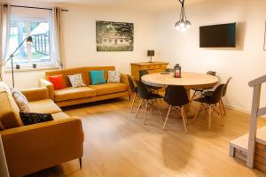 Kaszëbsko Nórcëk 8-10 osób 4 sypialnie jezioro las park linowy łowisko wędkarskie في Załakowo: غرفة معيشة بها طاولة وأريكة