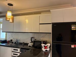 a kitchen with white cabinets and a black counter top at Stella Heights in El Alamein