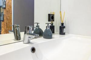 eine Badezimmertheke mit einem Waschbecken mit Spiegel in der Unterkunft Lapa 4 House in Porto