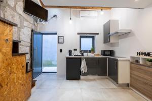eine Küche mit grauen Schränken und einer Steinmauer in der Unterkunft Lapa 4 House in Porto