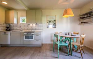 a kitchen with a table and chairs in a kitchen at Stunning Home In Myggenäs With Sauna in Höviksnäs