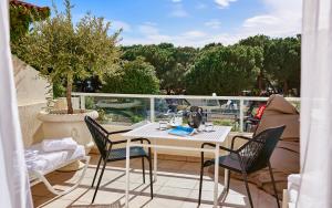 a patio with a table and chairs on a balcony at Hôtel Juana in Juan-les-Pins