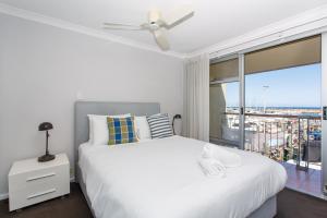 a bedroom with a white bed and a large window at Sunset Marina Escape Freo-amazing Views & Central in Fremantle