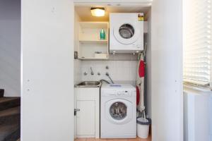 a small laundry room with a washer and dryer at Sunset Marina Escape Freo-amazing Views & Central in Fremantle