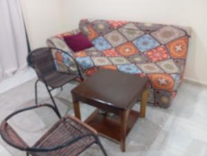 een woonkamer met een bank en twee stoelen bij Happy living room stay in Sharjah