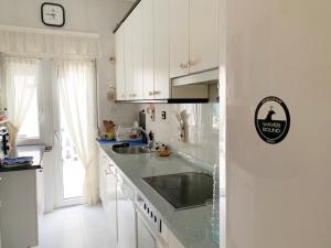 een witte keuken met een wastafel en een aanrecht bij Waves Sound Surf House Completo in Santoña +25 foto's