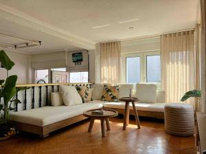 een woonkamer met een bank en een aantal ramen bij Waves Sound Surf House Completo in Santoña