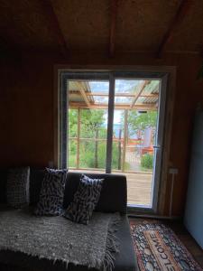 un sofá en una sala de estar con una gran ventana en Cabaña entre mares Huelmo, en Puerto Montt