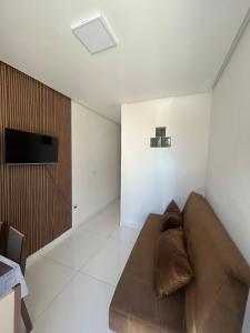 a living room with a brown couch and a tv at Casa siles 2 in Mucugê