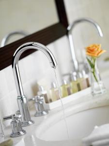 a sink with water coming out of a faucet at Hôtel Juana in Juan-les-Pins