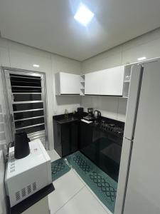 a small kitchen with a stove and a microwave at Casa siles 2 in Mucugê