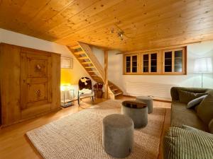 a living room with a couch and a wooden ceiling at Renovated traditional chalet in car-free Mürren in Mürren