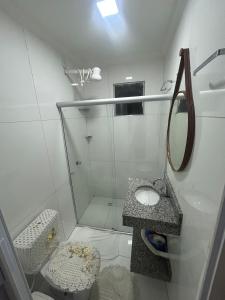 a white bathroom with a shower and a sink at Casa siles 2 in Mucugê +17 photos