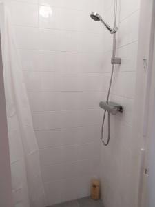 a white shower with a shower head in a bathroom at Stylish Cacilhas rooms near the ferry to central Lisbon in Almada