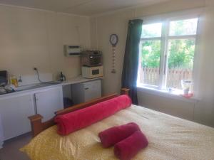 a bedroom with a bed with two pink pillows on it at The Batch in Lawrence