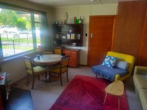 a living room with a table and a chair at The Batch in Lawrence