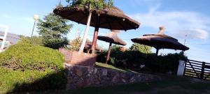 two umbrellas sitting on top of a stone wall at Del valle cabañas in Tanti +13 photos