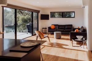 a living room with a couch and a table at Pods on Fraser in Bicheno