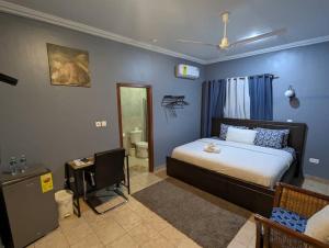 a bedroom with a bed and a bathroom at Bluegreen Guest House in Accra