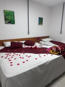 a bedroom with two beds with red roses on the bed at Pousada Brisa e Mar in Praia do Frances