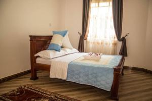 a bedroom with a bed with a window and a table at Fortbella Tourist Inn in Njara