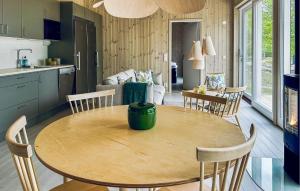 a kitchen and dining room with a wooden table and chairs at Cozy Home In Myggenäs With Sauna in Höviksnäs