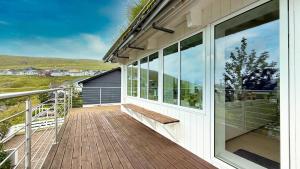 Exclusive Modern Villa with Panoramic Views في Vestmanna: شرفة منزل عليها مقعد